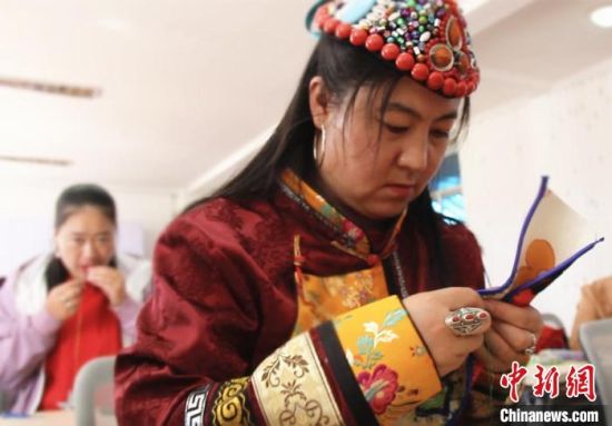 圖為裕固族婦女學(xué)習(xí)刺繡?！∈缝o靜 攝