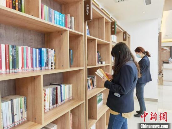圖為在甘肅公航旅建設(shè)集團(tuán)有限公司的職工書屋，職工挑選書籍?！⌒煅?攝