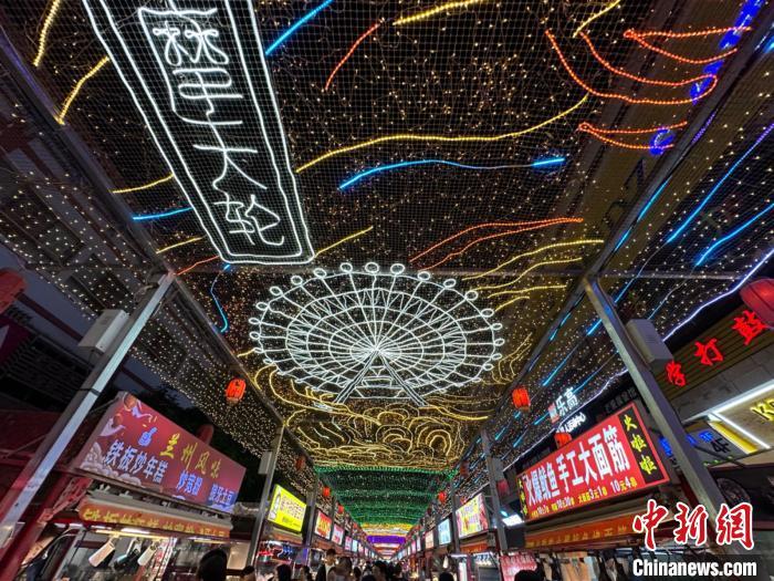 圖為明清街夜市燈光點(diǎn)亮具有武威文化元素的“摩天輪”彩燈?！〈魑牟?攝</p><p>