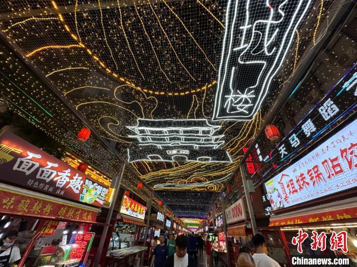 圖為明清街夜市燈光點(diǎn)亮具有武威文化元素的“涼州古城門”彩燈?！〈魑牟?攝</p><p>